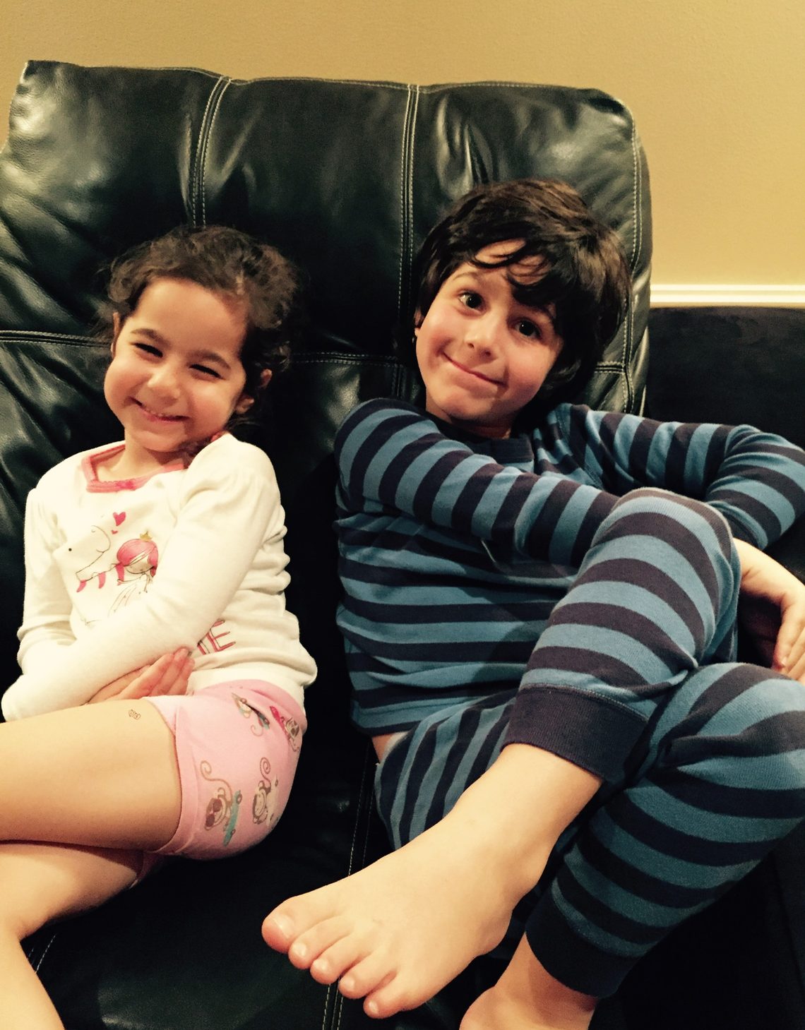 Eliot Abramson as a young boy on a couch beside a younger child.