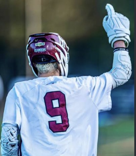 Eliot Abramson in his jersey, seen from behind, pointing one hand upward.